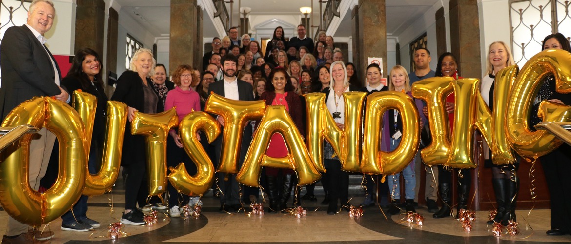 Kingston staff holding Outstanding balloons