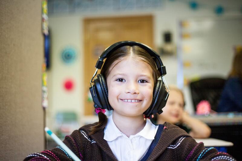 Child in classroom with headphones