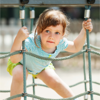 small female child on rope climbing frame