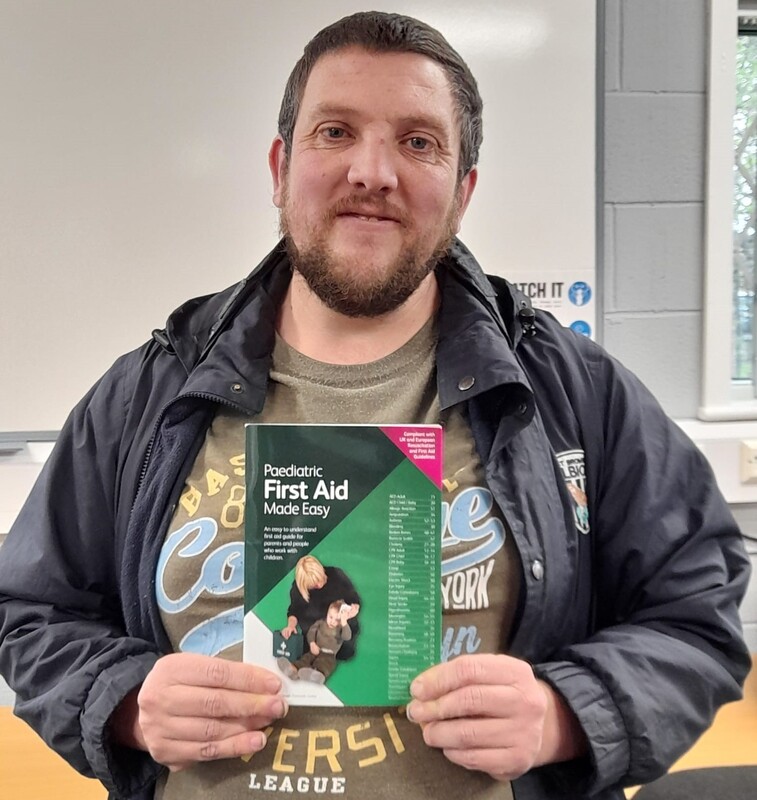 Man holding first aid text book