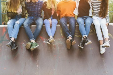 five young people sitting on wall