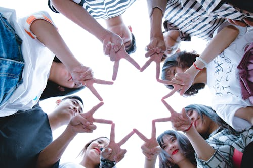 group of teenagers in a circle joining fingers together