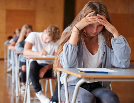 young people taking an exam in a formal setting