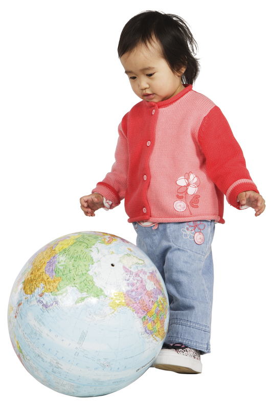 toddler kicking a plastic globe ball