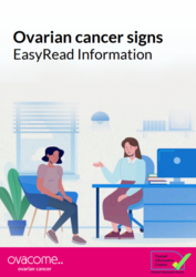 A person sitting at a desk with a computer and a person talking